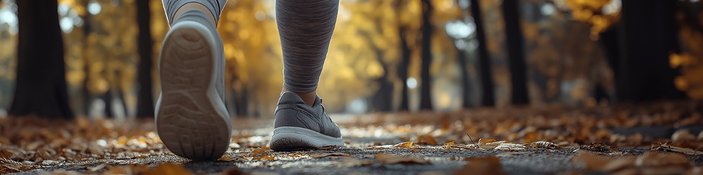 Beine in Sportschuhen bei Spaziergang im Herbstwald, Foto: KI_galam - AdobeStock