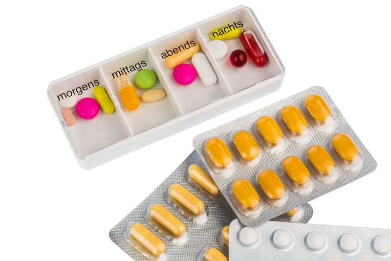 Tabletten liegen neben Tablettenspender