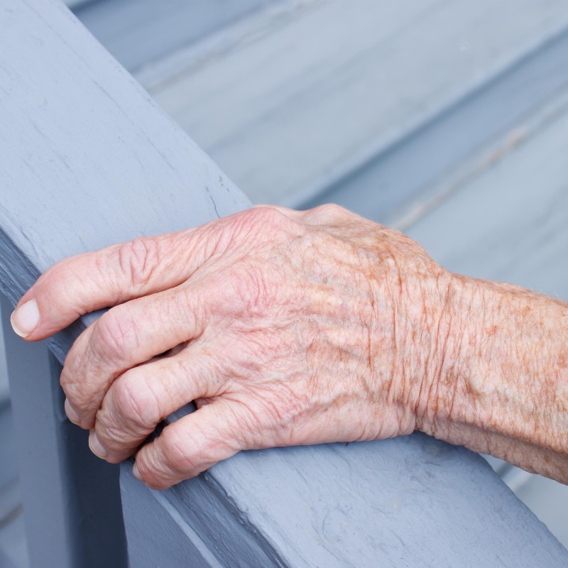 Hand einer älteren Frau hält sich an Stiegengeländer / Credit: shutterstock.com