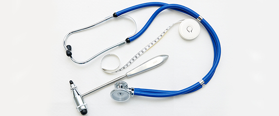 Typische Untersuchungsmaterialien zur medizinischen Diagnostik wie Stethoskop, Maßband und Reflexhammer