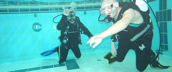 Zwei Personen unter Wasser mit Tauchausrüstung