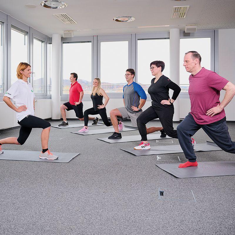 Gruppe macht mit Trainerin Gymnastik / Credit: Foto Flausen